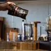 A kitchen scene where Cooper's Craft Coffee is being poured into a French press showing the coffee flavor profile