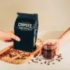 a bag of unroasted coffee and a cup of coffee with opposing hands to show how long does coffee last