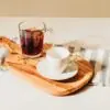 Two cups of bourbon coffee and a biscottie sitting on a cutting board to represent naturally flavored coffee